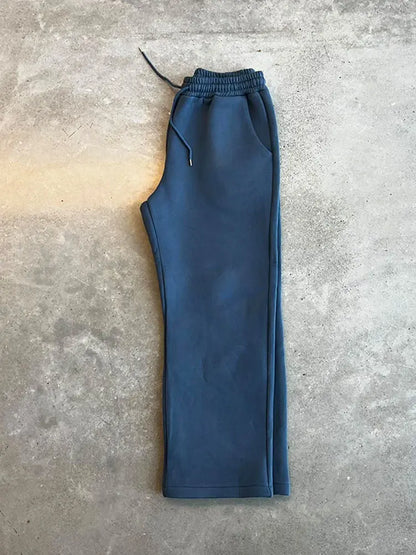 Pantaloni tuta blu su sfondo grigio, moda casual, abbigliamento sportivo, tessuto morbido, stile comodo, pantaloni elastici con coulisse.