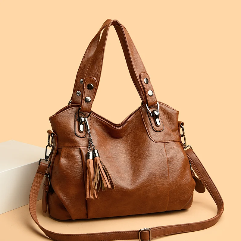 Borsa a tracolla in pelle marrone con nappe decorative, design elegante e moderno, perfetta per moda donna e accessori di tendenza.