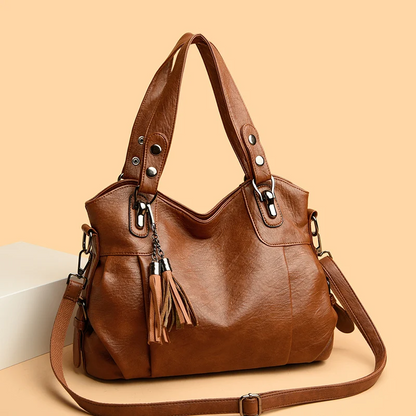 Borsa a tracolla in pelle marrone con nappe decorative, design elegante e moderno, perfetta per moda donna e accessori di tendenza.