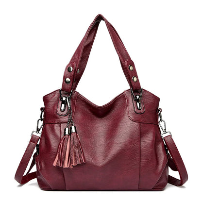 Borsa a spalla in pelle rossa con nappine decorative, manici robusti e tracolla regolabile. Elegante e spaziosa, ideale per ogni occasione.