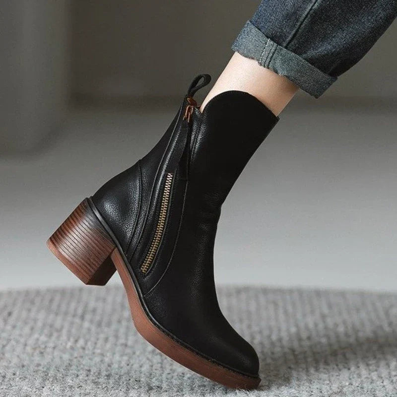 Stivaletto nero in pelle con tacco largo e cerniera laterale, indossato con jeans. Scarpe moda autunno inverno, eleganti e versatili.