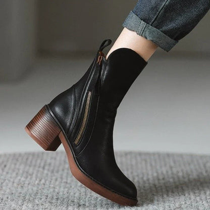 Stivaletto nero in pelle con tacco largo e cerniera laterale, indossato con jeans. Scarpe moda autunno inverno, eleganti e versatili.