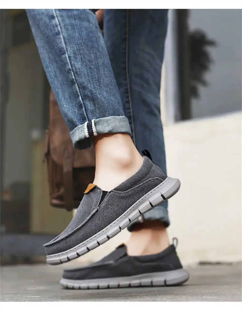 Scarpe casual uomo grigie, suola antiscivolo, indossate con jeans. Calzature comode e traspiranti per passeggiate e tempo libero.