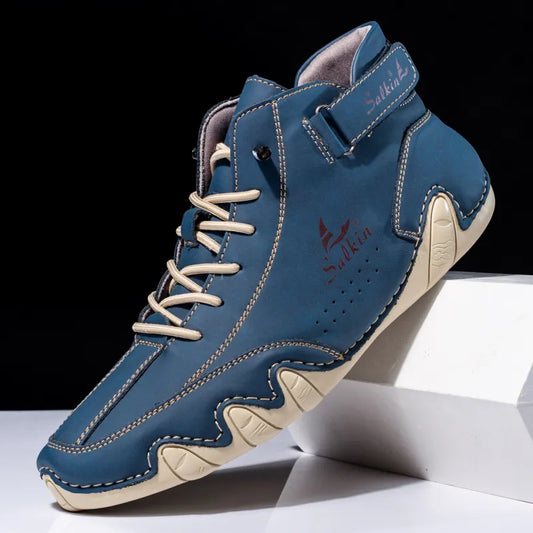 Scarpa sportiva alta blu con lacci bianchi, suola beige antiscivolo e chiusura a strappo. Design moderno, ideale per attività all'aperto e casual.