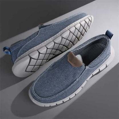 Scarpe casual da uomo in tessuto denim blu, suola bianca antiscivolo, design slip-on, ideali per moda urbana e comfort quotidiano.