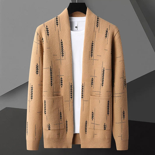 Cardigan beige con motivo a foglie nere, tasche frontali, su sfondo grigio. Maglione elegante, moda autunnale, abbigliamento casual uomo.