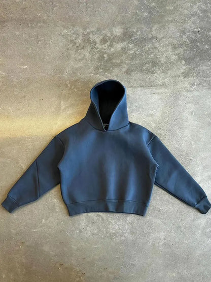 Felpa con cappuccio blu scuro su sfondo grigio, design minimalista, moda casual, abbigliamento streetwear, tendenza autunno inverno.