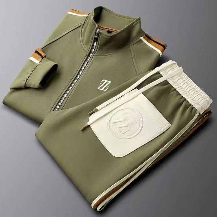 Tuta sportiva verde oliva con zip, dettagli a righe marroni, tasca bianca con logo. Abbigliamento casual elegante, moda uomo, stile athleisure.