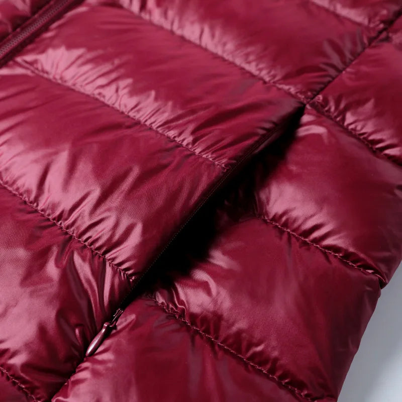 Giacca piumino rosso bordeaux, tessuto trapuntato lucido, chiusura con zip. Moda invernale, abbigliamento caldo, stile casual elegante.