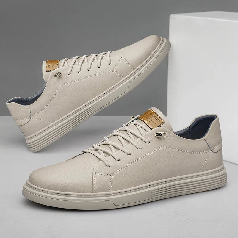 Scarpe da ginnastica bianche eleganti, design minimalista, suola in gomma, dettagli in pelle marrone, perfette per look casual e moderni.