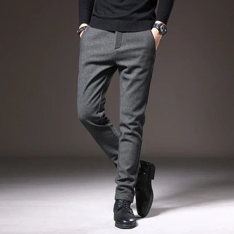 Pantaloni eleganti grigi da uomo, vestibilità slim, abbinati a scarpe nere e maglione scuro. Moda maschile autunno-inverno.