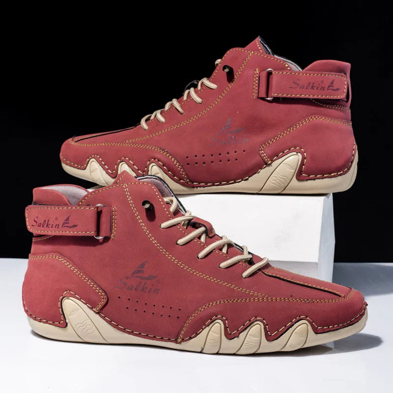 Scarpe da ginnastica alte rosse in pelle scamosciata con cuciture beige, suola in gomma, design moderno, stile casual sportivo, marchio visibile.