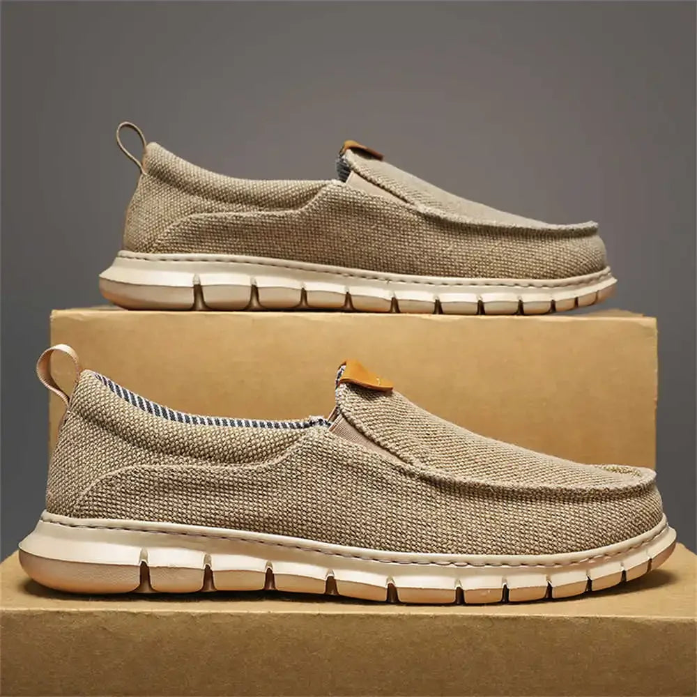 Scarpe slip-on beige in tessuto traspirante su scatole di cartone, suola bianca flessibile. Calzature casual uomo, moda estiva, comfort quotidiano.