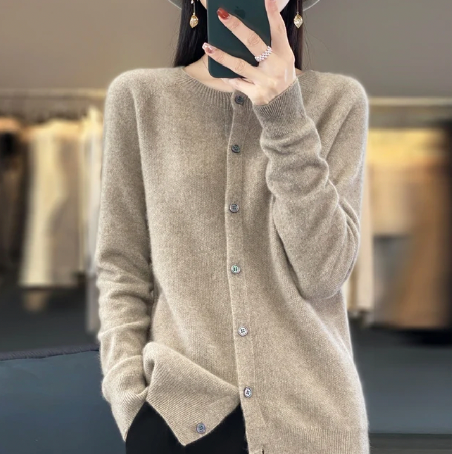 Donna con cardigan beige in cashmere, bottoni frontali, mani in tasca. Moda autunno inverno, abbigliamento elegante e confortevole.