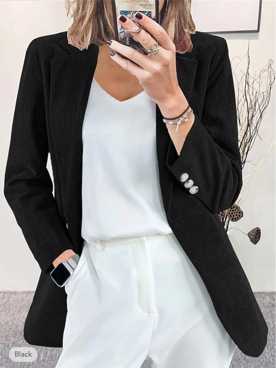 Donna in abito elegante: blazer nero a coste, top bianco, pantaloni bianchi. Moda femminile, stile business casual, outfit sofisticato.