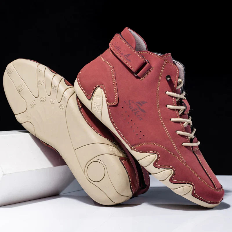 Scarpe da basket rosse in pelle con suola beige, design moderno e lacci, su sfondo nero. Calzature sportive eleganti e confortevoli.