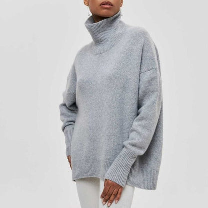 Maglione grigio a collo alto in lana, indossato da una persona su sfondo bianco. Moda invernale, abbigliamento caldo ed elegante.