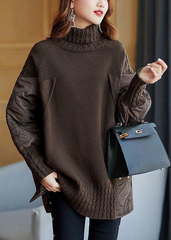Donna con maglione marrone a collo alto, maniche in pelle, borsa a mano nera elegante, orecchini pendenti, moda autunnale chic.