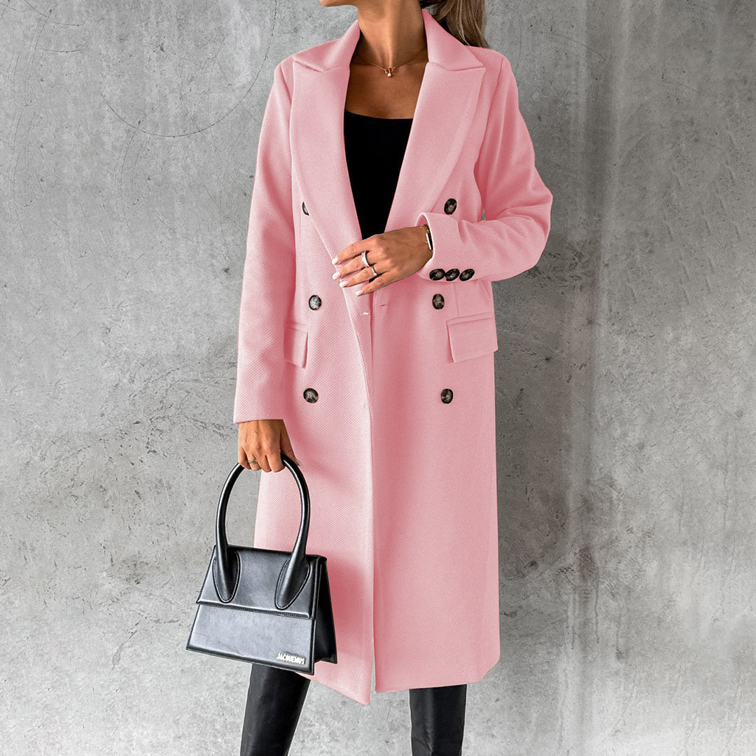 Donna con cappotto rosa elegante, borsa nera, sfondo grigio. Moda autunnale, stile chic, abbigliamento femminile di tendenza.