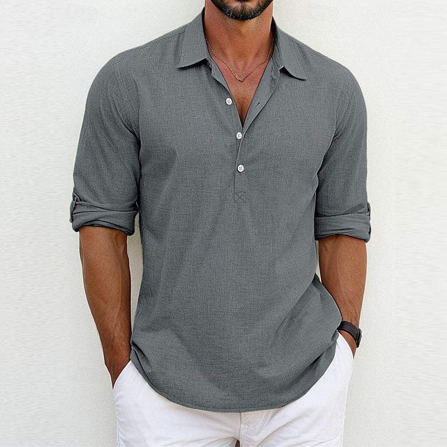 Camicia uomo grigia a maniche lunghe, stile casual, con colletto aperto e bottoni, abbinata a pantaloni bianchi. Moda maschile elegante e moderna.
