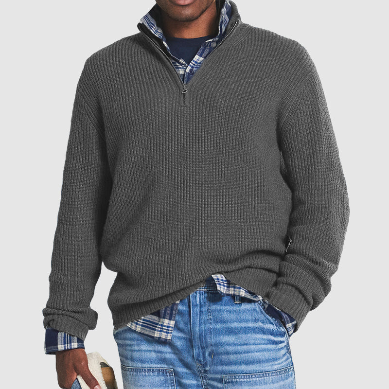 Maglione grigio a collo alto con zip, indossato su camicia a quadri blu e jeans. Moda uomo casual, abbigliamento invernale elegante.
