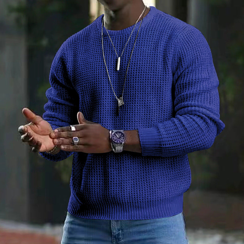 Maglione blu a maglia indossato da uomo con orologio e collane, sfondo urbano sfocato. Moda maschile, abbigliamento casual elegante.