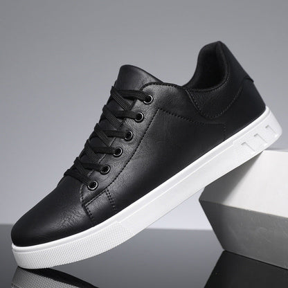 Scarpa da ginnastica nera in pelle sintetica con suola bianca, design moderno, lacci neri, ideale per moda casual e sportiva.