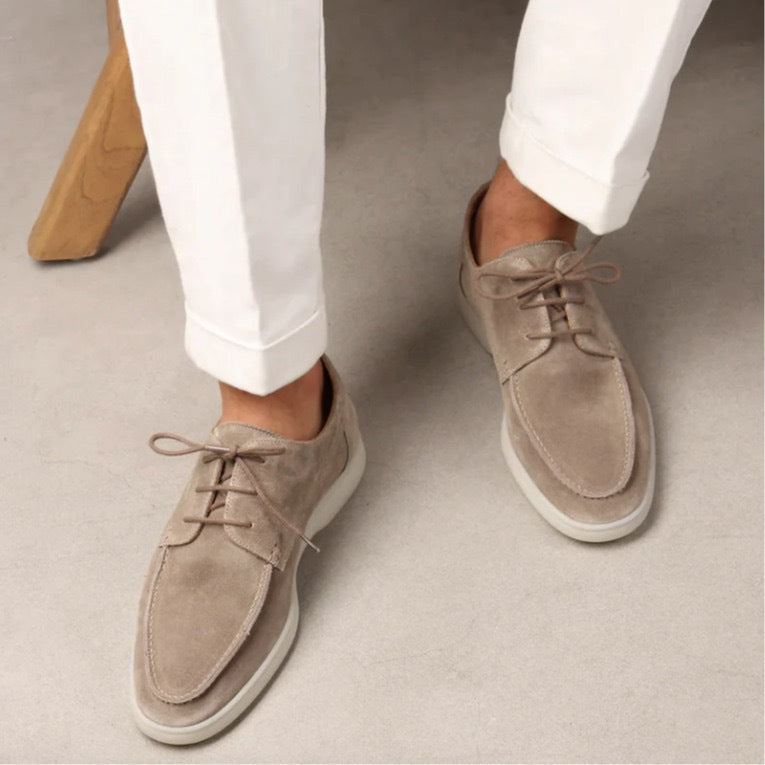 Men’s suede-style boat shoes with laces, moccasin stitching, and a thick contrasting sole.