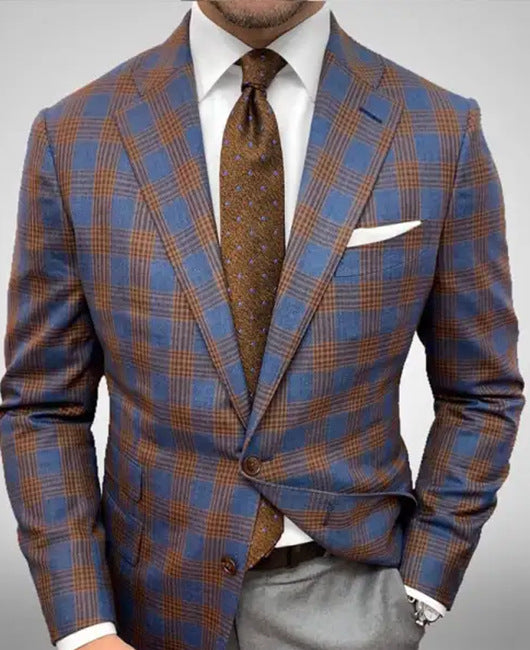 Giacca a quadri blu e marrone su uomo elegante, camicia bianca, cravatta marrone, fazzoletto da taschino bianco. Moda maschile, abbigliamento formale.