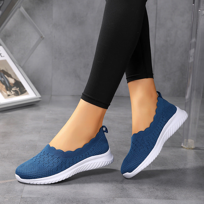 Scarpe da donna blu in maglia traspirante, suola bianca, indossate con leggings neri. Design casual e comodo, ideale per passeggiate e tempo libero.