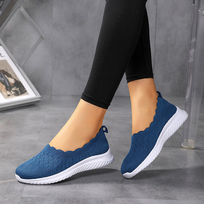 Scarpe da donna blu in maglia traspirante, suola bianca, indossate con leggings neri. Design casual e comodo, ideale per passeggiate e tempo libero.
