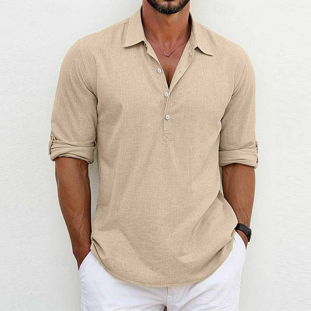 Camicia uomo beige a maniche lunghe, stile casual, con colletto aperto e bottoni, abbinata a pantaloni bianchi. Look estivo elegante e rilassato.