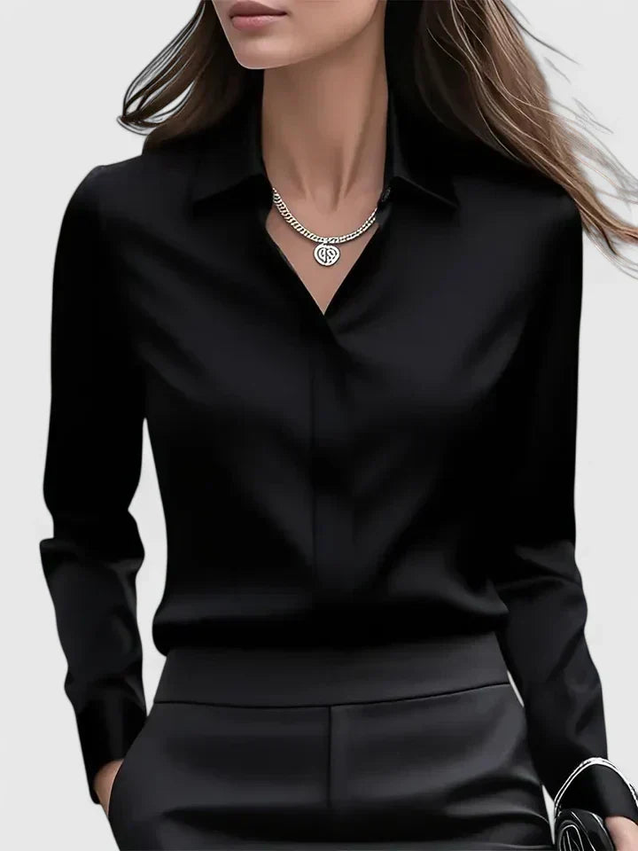 Donna in camicia nera elegante, collana d'argento, capelli sciolti. Moda femminile, abbigliamento formale, stile sofisticato.
