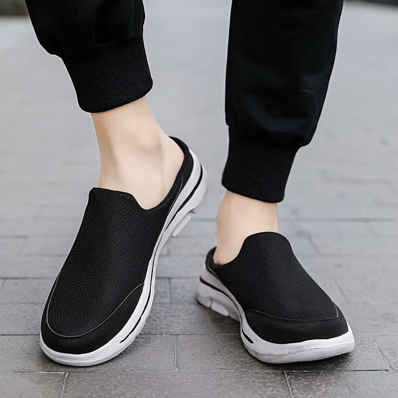 Scarpe slip-on nere da uomo su pavimento grigio, design casual e sportivo, suola bianca, ideali per passeggiate e tempo libero.