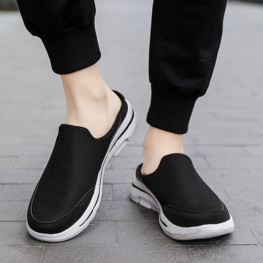 Scarpe slip-on nere da uomo su pavimento grigio, design casual e sportivo, suola bianca, ideali per passeggiate e tempo libero.