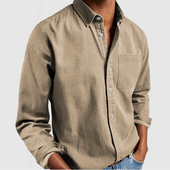 Camicia casual beige da uomo in cotone, con taschino sul petto e bottoni, indossata con jeans. Stile elegante e moderno per moda maschile.