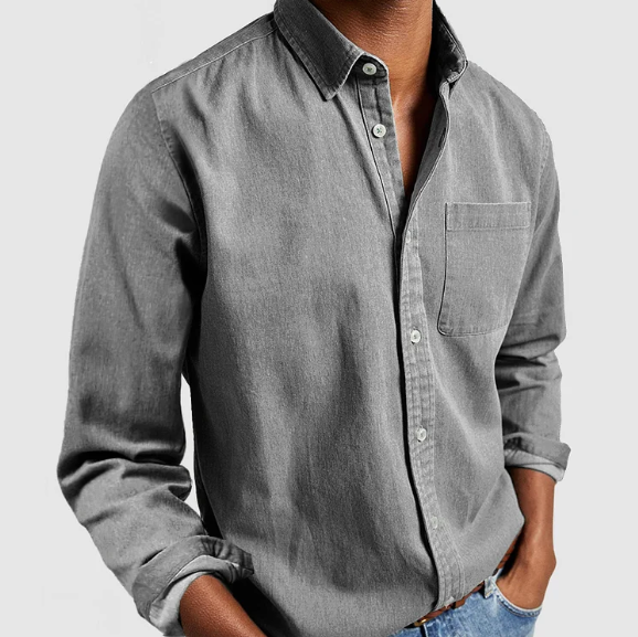 Camicia uomo grigia in denim, maniche lunghe, taschino frontale, abbinata a jeans. Moda casual maschile, stile elegante e moderno.