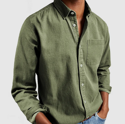 Camicia verde oliva da uomo in cotone, maniche lunghe, con taschino, abbinata a jeans. Stile casual elegante, moda maschile contemporanea.