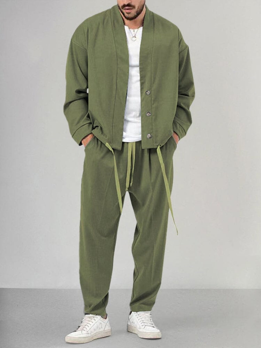 Uomo in abbigliamento casual verde oliva, giacca e pantaloni coordinati, con t-shirt bianca e sneakers bianche. Moda maschile moderna e rilassata.