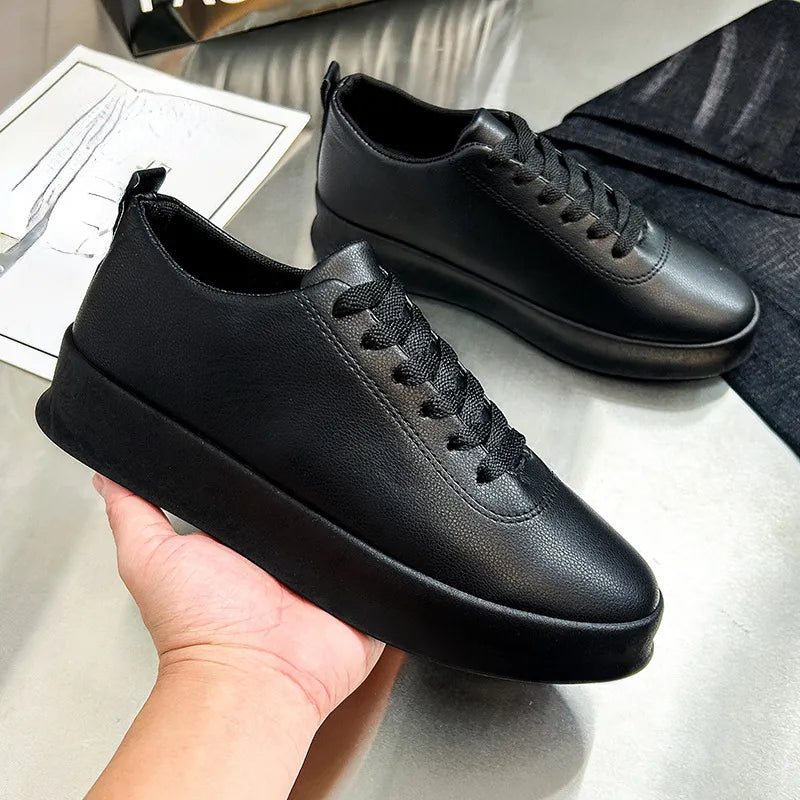 Scarpe da ginnastica nere in pelle su tavolo, design moderno e minimalista, suola spessa, lacci neri, moda casual, calzature eleganti.