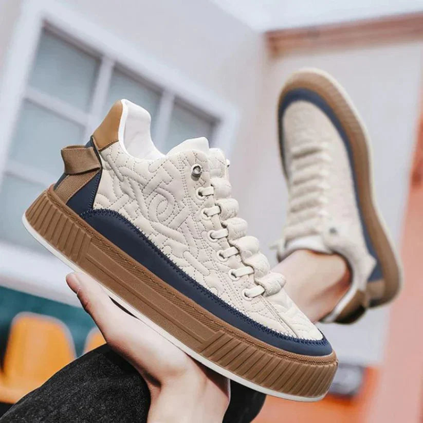 Scarpe da ginnastica beige con dettagli blu e marroni, suola spessa, design trapuntato. Scarpe casual moda uomo, stile urbano moderno.