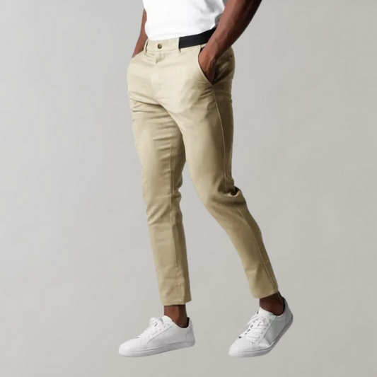 Pantaloni chino beige da uomo, eleganti e casual, abbinati a scarpe da ginnastica bianche. Stile moderno, perfetti per look quotidiani.