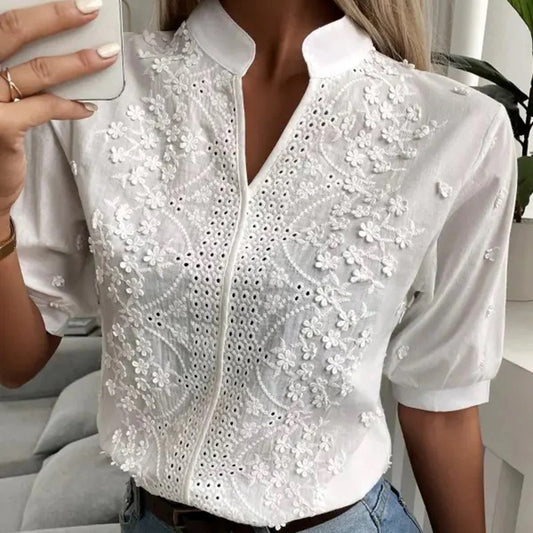 Camicia bianca elegante da donna con ricami floreali, maniche corte e colletto alla coreana. Perfetta per look estivi e casual chic.