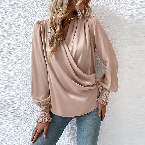Blusa elegante in raso beige con maniche lunghe e polsini arricciati, indossata con jeans. Look moda donna, stile casual chic.