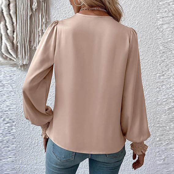 Donna con camicetta beige a maniche lunghe e jeans, vista posteriore. Moda casual femminile, tessuto morbido, stile elegante. Sfondo tessuto decorativo.