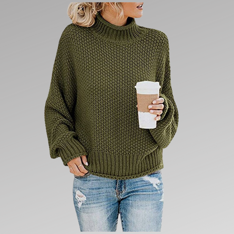 Donna con maglione verde a collo alto, tiene una tazza di caffè. Indossa jeans strappati. Moda autunnale casual, look confortevole e trendy.