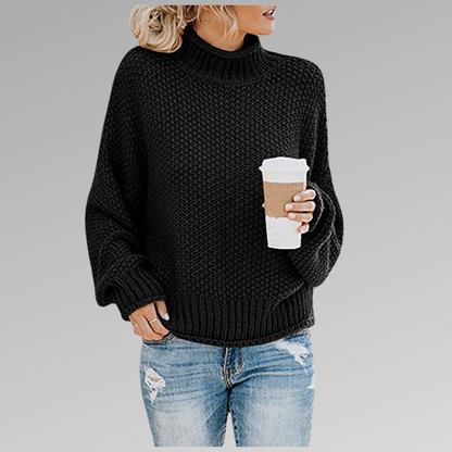 Donna con maglione nero a collo alto, jeans strappati e caffè da asporto. Moda casual autunnale, stile urbano, abbigliamento comodo.