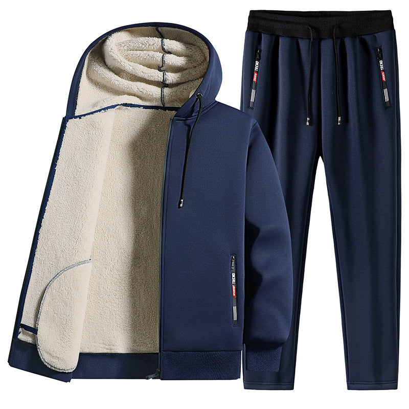 Tuta sportiva invernale blu scuro con cappuccio e fodera in pile, pantaloni con coulisse. Abbigliamento caldo e comodo per attività all'aperto.