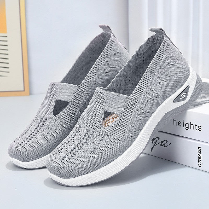 Scarpe da ginnastica grigie in tessuto traspirante, design slip-on, suola bianca antiscivolo. Ideali per camminata e sport, comfort e stile casual.