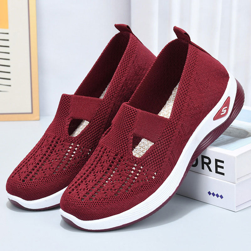 Scarpe da ginnastica rosse in tessuto traspirante, suola bianca antiscivolo, design moderno e confortevole, ideali per sport e tempo libero.